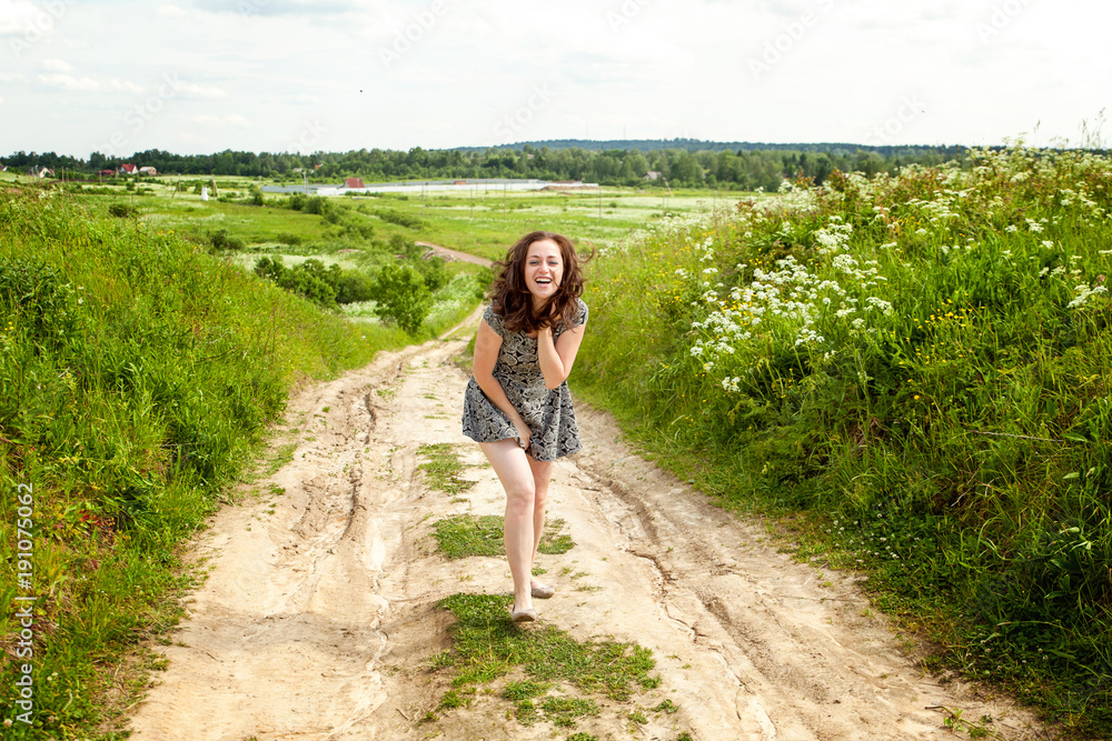 Naklejka premium Beauty Girl Outdoors enjoying nature. Beautiful woman jumping on summer Field with blooming wild flowers, Sun Light. Free Happy Woman