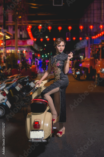 Portrait of asian woman in black dress on the walkway in downtown night scene close up a girl street style