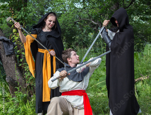 three knights in armor is fighting  at forest