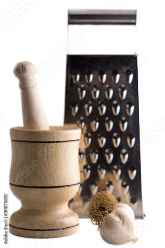 Metal grater, garlic in mortar and pestle