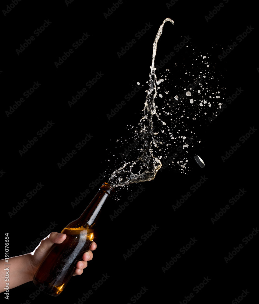 Gold beer bottle opening with exploding and splashing on dark ...