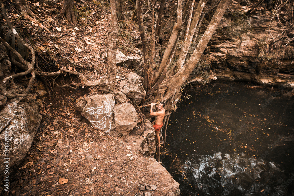 Man swimming in natural Cenote in Mexico Man swimming in natural Cenote in Mexico