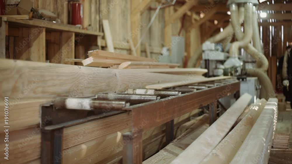 Wood board running out carpenter refiner machine at sawmill factory, lots of sawdust Wood board running out carpenter refiner machine at sawmill factory, lots of sawdust