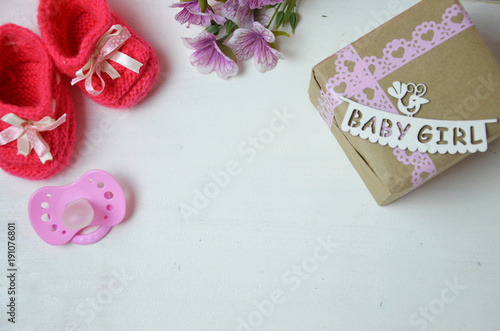 Fototapeta Naklejka Na Ścianę i Meble -  A newborn baby girl background. Newborn accessories for a baby girl on a pink wooden background.