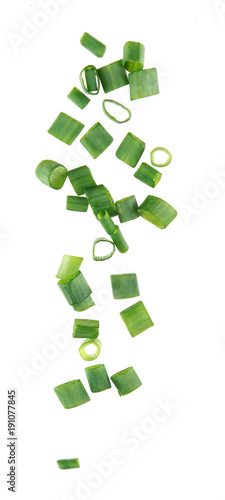 Flying pieces of chopped green onion on white background