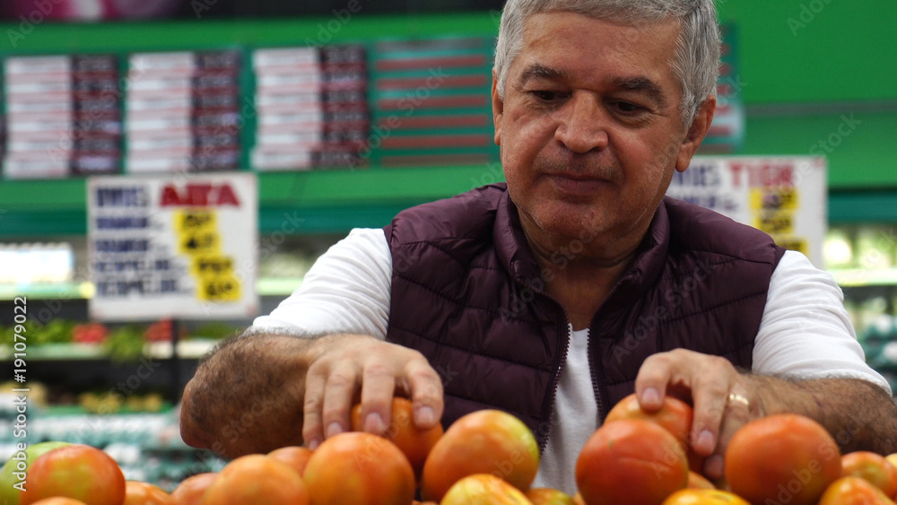 Man Choosing Tomatoes at Supermarket Man Choosing Tomatoes at Supermarket