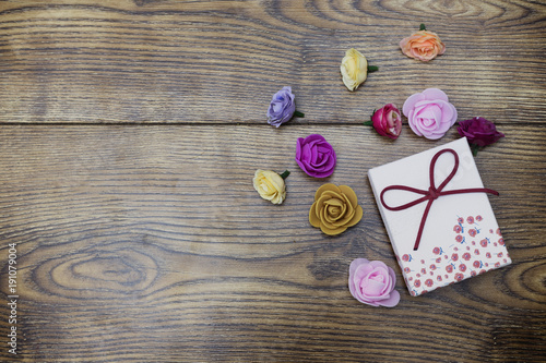 Love day concept. Gift box with group of roses over wooden table. Top view with copy space
