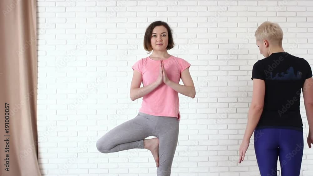 Instructor helping girl to do asana Instructor helping girl to do asana