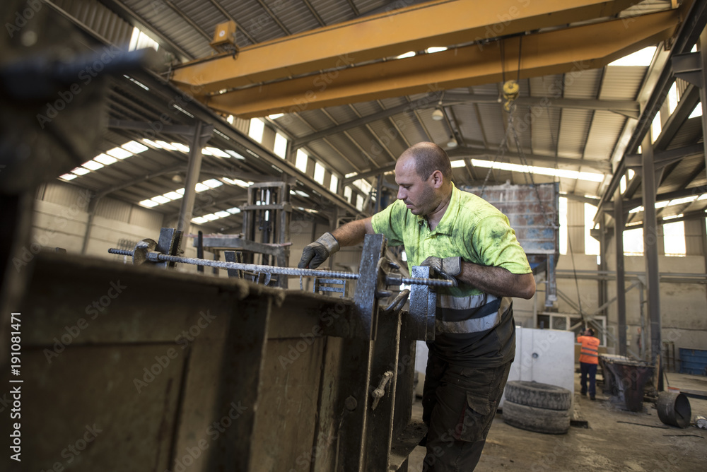 Man measuring and hammering concrete structure for create a construction piece Man measuring and hammering concrete structure for create a construction piece