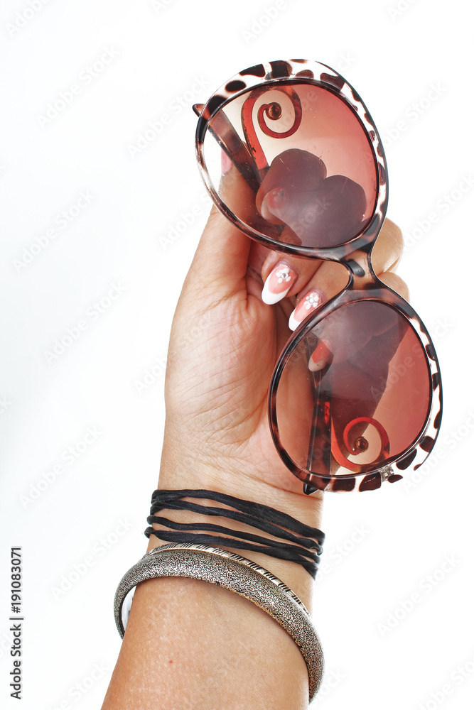 Woman hand holding sunglasses on isolated white cutout background. Studio photo with studio lighting easy to use for every concept. Woman hand holding sunglasses on isolated white cutout background. Studio photo with studio lighting easy to use for every concept.