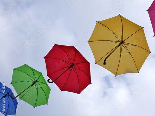 Bunte Regenschirme fliegen an einem windigen Sommertag durch die Luft