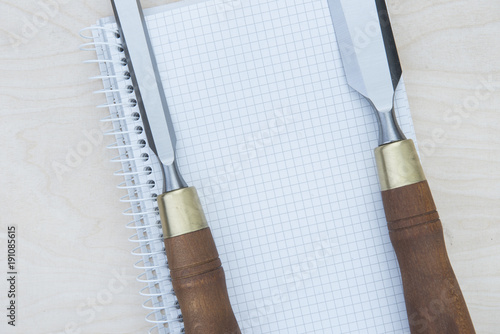 a professional chisel on a wooden background with a notebook