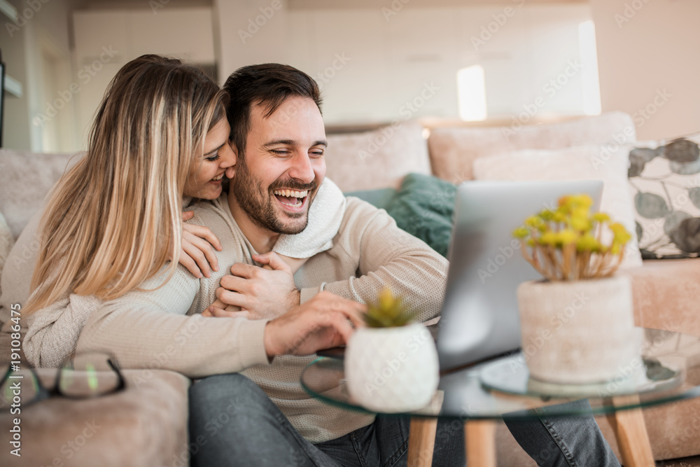 Happy young couple with laptop