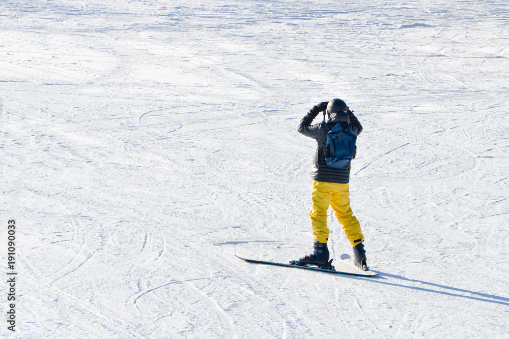 BUKOVEL, UKRAINE- 27 JANUARY 2018: Man on skis looks afar. View from the back BUKOVEL, UKRAINE- 27 JANUARY 2018: Man on skis looks afar. View from the back