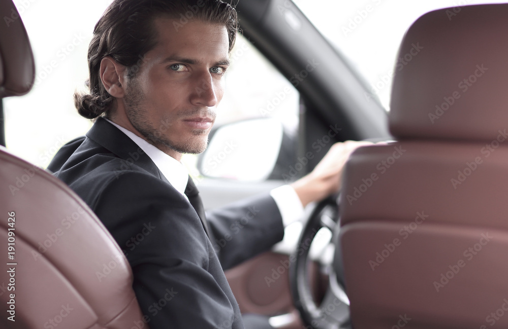 man sitting behind the wheel of a car man sitting behind the wheel of a car