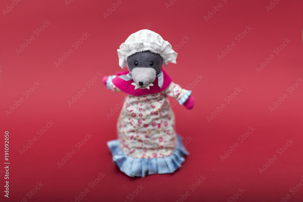 Big bad wolf dressed in grandma clothes cute rag or fabric doll isolated on a red background