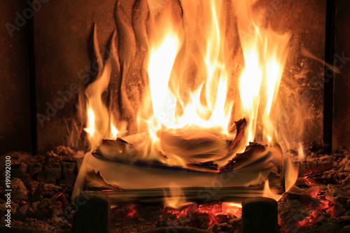 Płomienie ognia w kominku, spalanie papietu.
