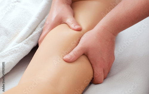 The masseur makes Anti-cellulite massage on the buttock and thighs of the patient. Treatment of excess weight.