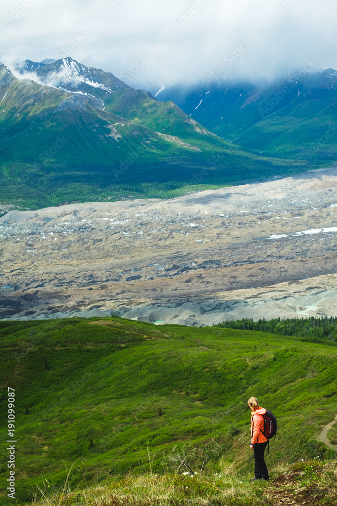 Woman hiking in the mountains. Enjoying the view. Active life. Alaska range. Glacier.