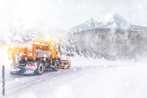 Snowplow cleared the snow-covered icy road