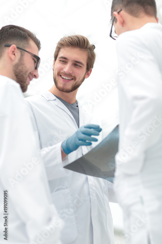 smiling doctors discussing x-ray with colleagues