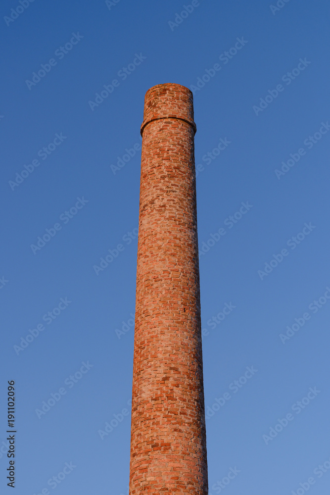 brick factory chimney against the blue sky