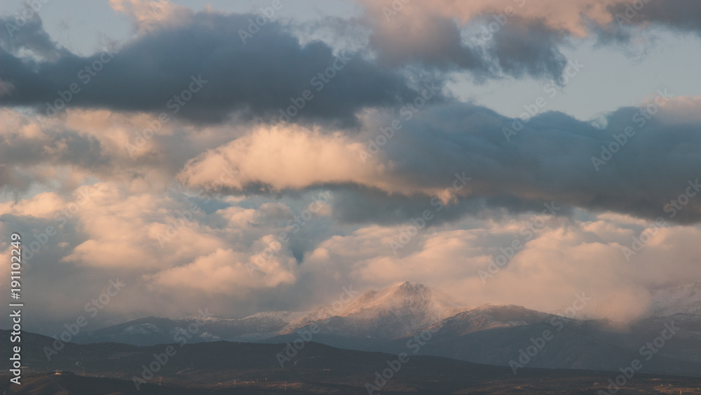 Cloudy sunset over snow-covered mountains