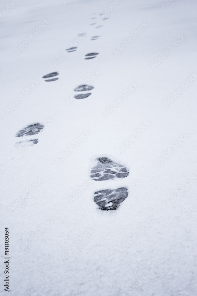 Winter foot steps in the snow on the ground