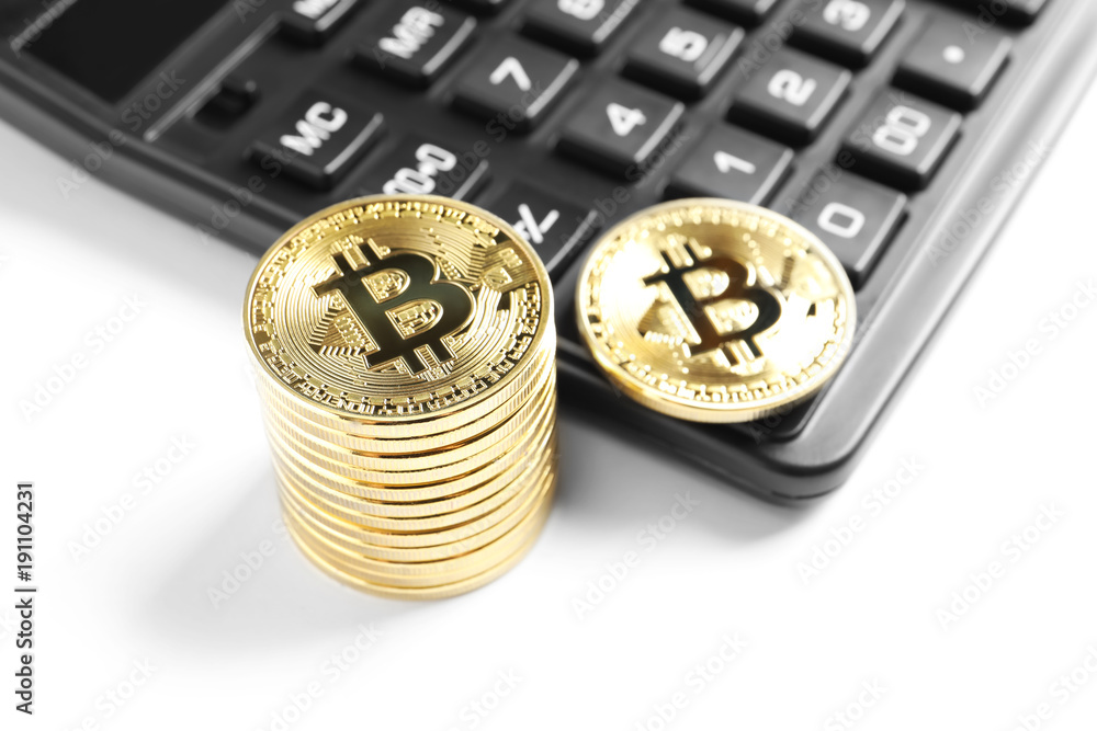 Golden bitcoins with calculator on white background
