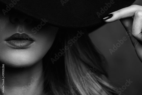 Photography Beautiful young mysterious blond girl in black hat and black jacket on gray background