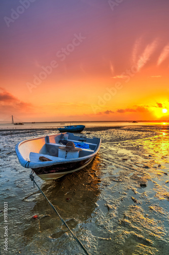 Long exposure picture of fishing boat with golden sunset as a background