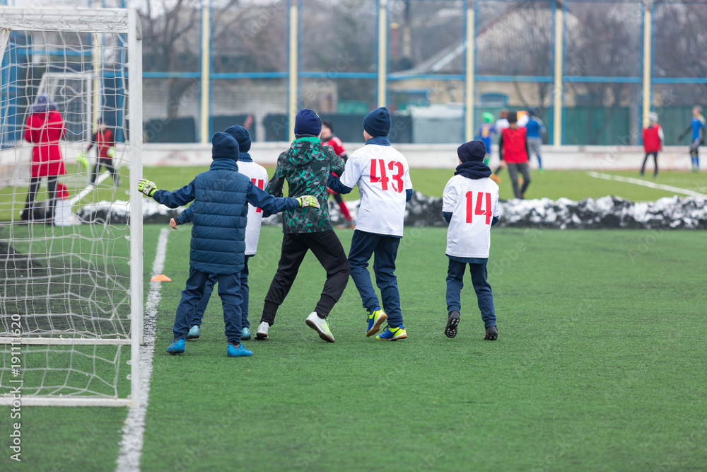 Obraz premium boys play football tournament at winter stadium. 