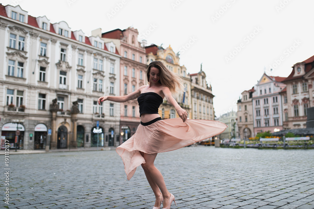 Woman dancing in a flower dress at old town square in prague, czech replic