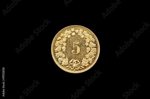 A macro image of a Swiss 5 centimes coin isolated on a black background
