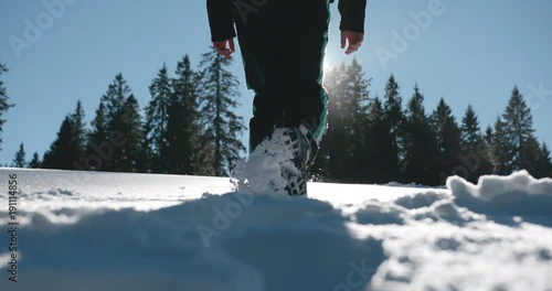 Person walking in high snow on a beautiful snowy day in slow motion