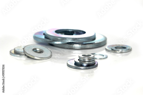 Variety of industrial galvanized steel washers on white