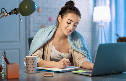 Young woman working late in...