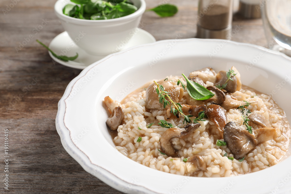 Plate with delicious risotto and mushrooms on table Plate with delicious risotto and mushrooms on table