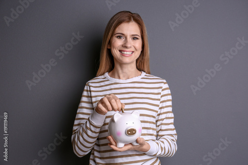 Young woman putting coin in...