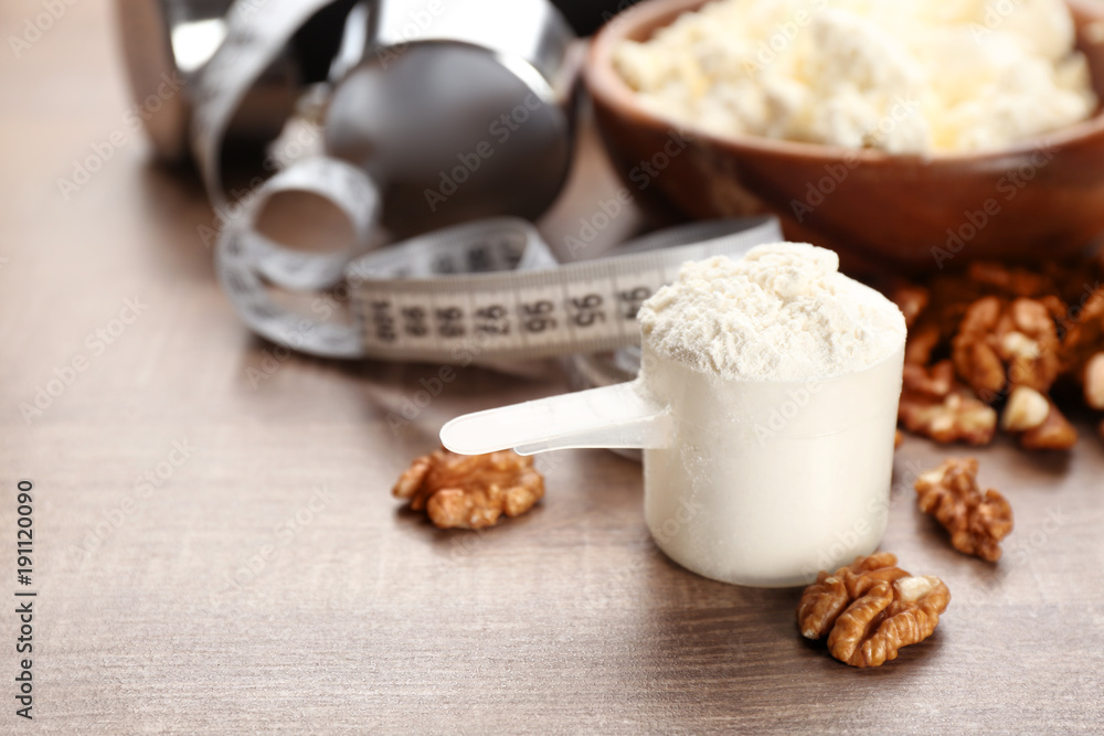 Scoop with protein powder and products on table Scoop with protein powder and products on table