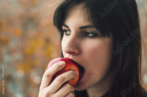 Young woman eating a red apple