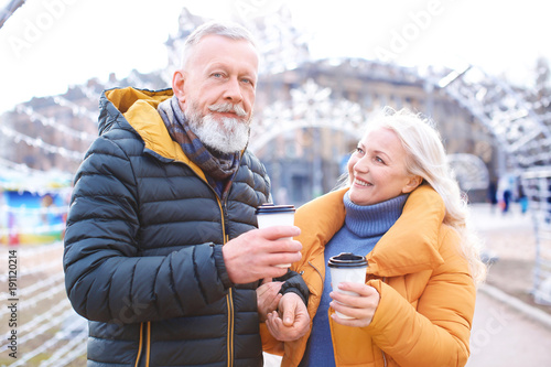 Happy mature couple with coffee outdoors