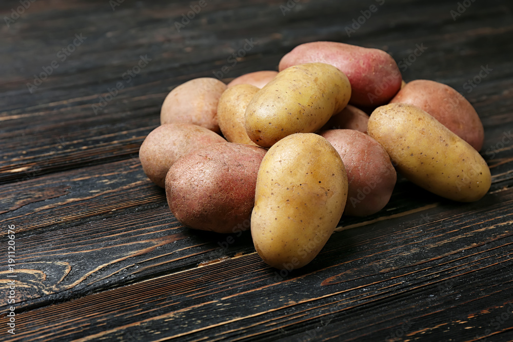Fresh raw potatoes on wooden table Fresh raw potatoes on wooden table