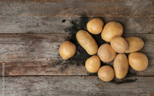 Fresh raw potatoes on wooden table, top view