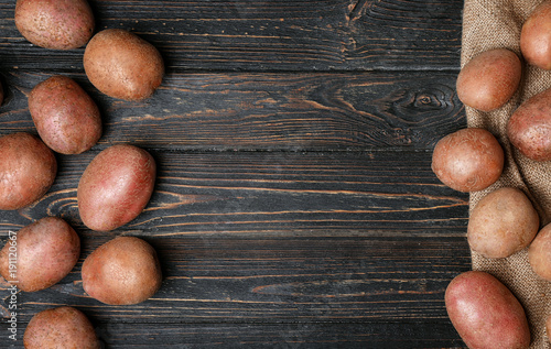 Fresh raw potatoes on wooden table, top view