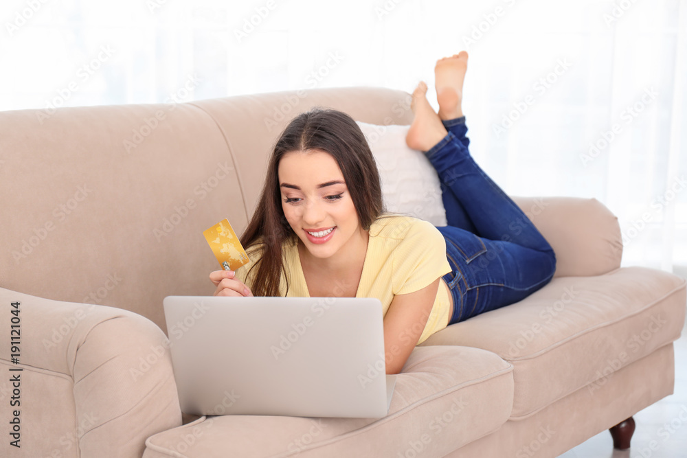 Young woman shopping online with credit card and laptop at home Young woman shopping online with credit card and laptop at home