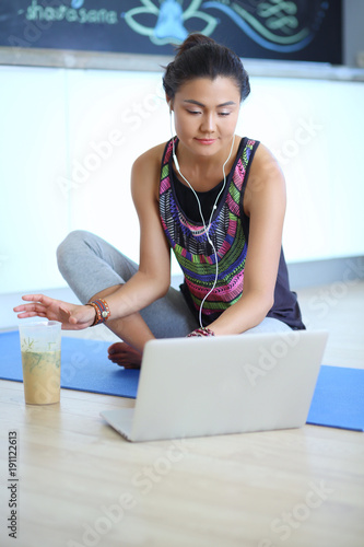 Sporty smiling woman using laptop in bright room. Woman. Lifestyle photo