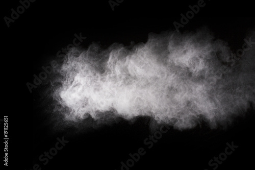 Freeze motion of white dust explosion on black background. Stopping the movement of white powder on dark background. Explosive powder white on black background. © kitsana