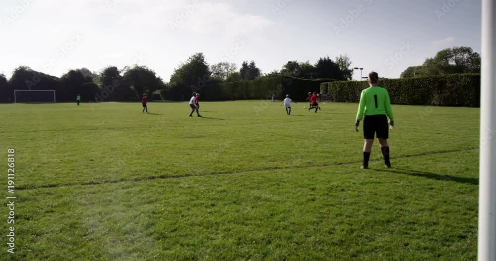 Caucasian boys playing football together at a soccer ground. Shot on RED Epic. Caucasian boys playing football together at a soccer ground. Shot on RED Epic.