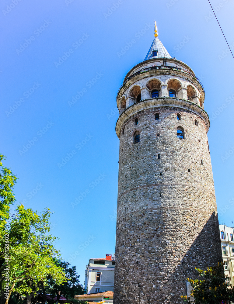 The tall and mighty Galata tower in Turkey, Istanbul. Shot against a beautiful blue sky with a slight hint of Cirrus clouds